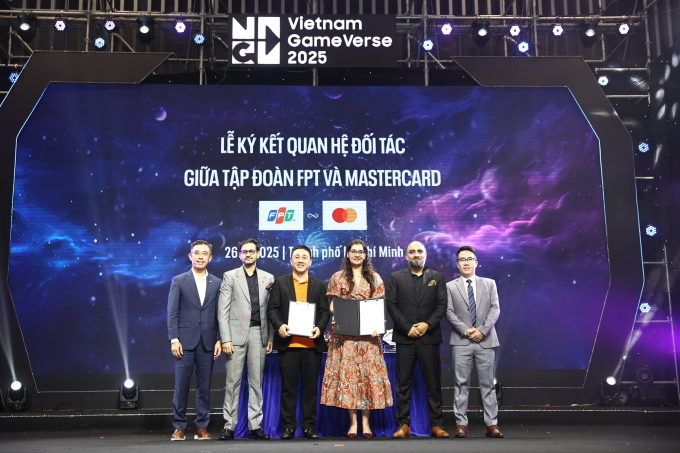 Ông Phạm Duy Phúc, Giám đốc chiến lược DC5, FPT (áo cam) và bà Aisha Islam, Phó chủ tịch Cấp cao, phụ trách Trung tâm Giải pháp Khách hàng khu vực Đông Nam Á, Mastercard thực hiện lễ ký kết. Ảnh: Quỳnh Trần