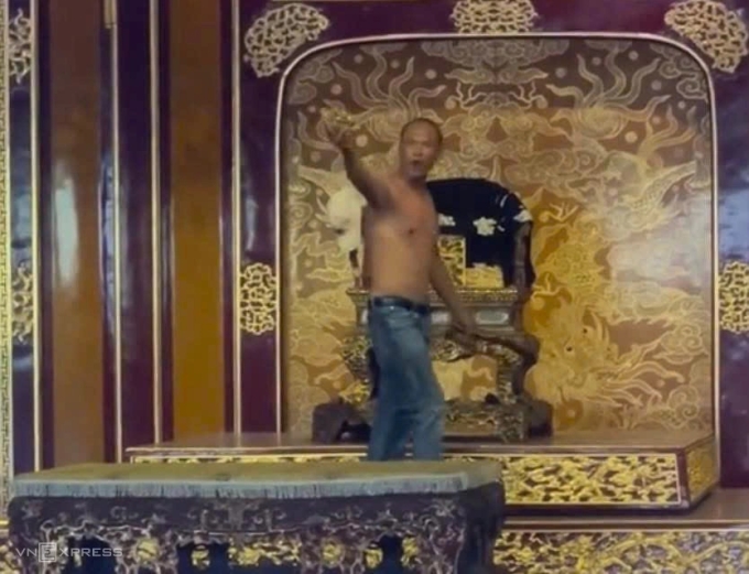 Hồ Văn Phương Tâm ở trần, có biểu hiện bất thường sau khi bẻ gãy ngai vàng triều Nguyễn, trưa 24/5. Ảnh: Vạn An
