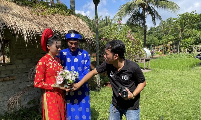 Anh Trung Hiếu đang hướng dẫn cho cặp vợ chồng là công nhân nhà máy chụp ảnh tự tin hơn, năm 2024. Ảnh: Nhân vật cung cấp