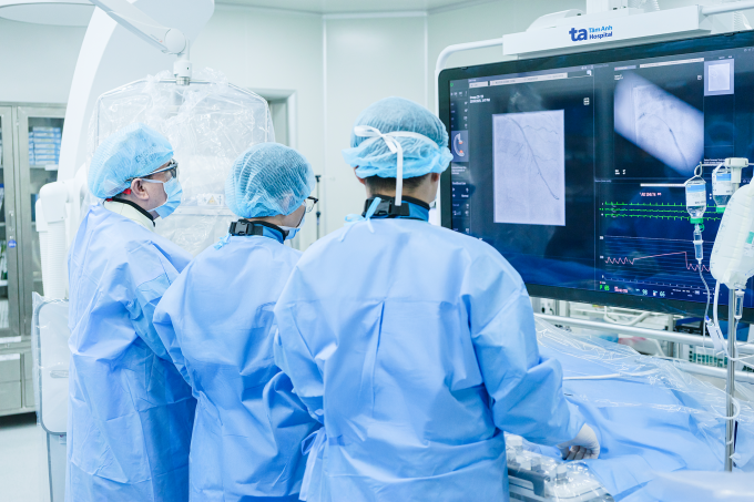 Giáo sư Nhân (bên trái) cùng êkíp bác sĩ đặt stent cho người bệnh. Ảnh minh họa: Thanh Luận