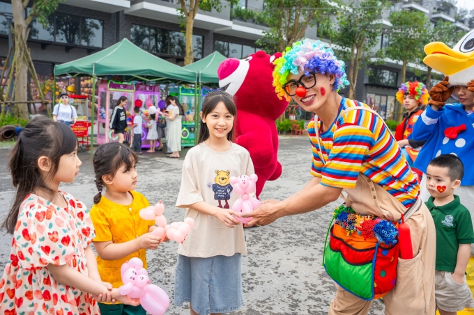 Trẻ tạo hình bóng bay cùng chú hề tại phố đi bộ Hùng Vương, Eco Central Park trong sự kiện trước đó. Ảnh: Thanh Sơn