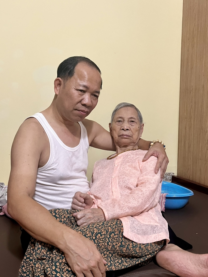 Đỗ Văn Hương (trái), 52 tuổi, ở quận Hoàng Mai, Hà Nội đang dỗ dành mẹ già U100 bị mất trí nhớ, tháng 5/2025. Ảnh: Nhân vật cung cấp