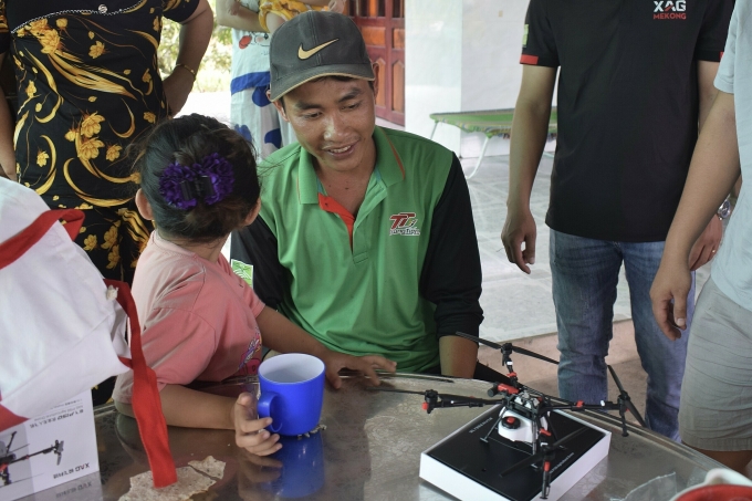 Đoàn giới thiệu máy drone nông nghiệp cho người dân. Ảnh: XAG