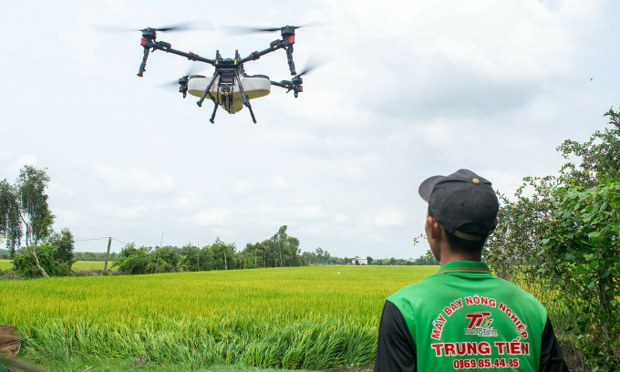 Nông dân điều khiển drone phun thuốc. Ảnh: XAG