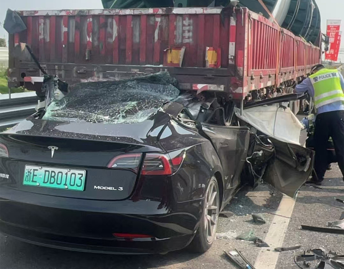 Chiếc Tesla Model 3 rúc vào gầm rơ-moóc đến hơn nửa thân xe. Ảnh: JiaweiShen