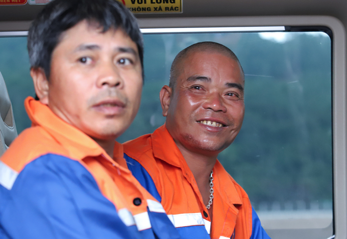 Ông Lập (góc phải) mỉm cười sau được cứu, đưa lên bờ an toàn. Ảnh: Đức Hùng