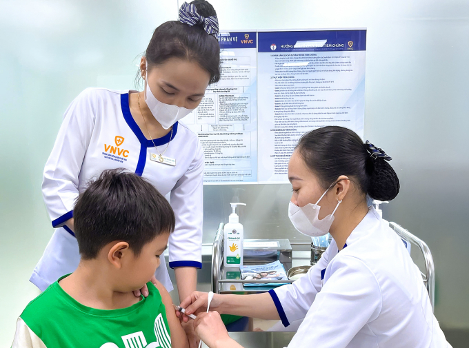 Phụ huynh đưa trẻ đi tiêm ngừa tại Trung tâm tiêm chủng VNVC. Ảnh: Mộc Thảo