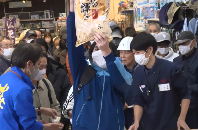 Một thanh niên vui mừng khi mua thành công một bao gạo 5 kg tại Matsudo, Chiba. Ảnh: Mainichi