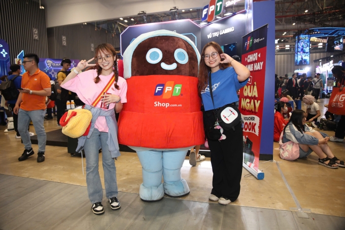 Khách tham quan chụp ảnh check-in cùng mascot tại gian hàng. Ảnh: FPT Shop