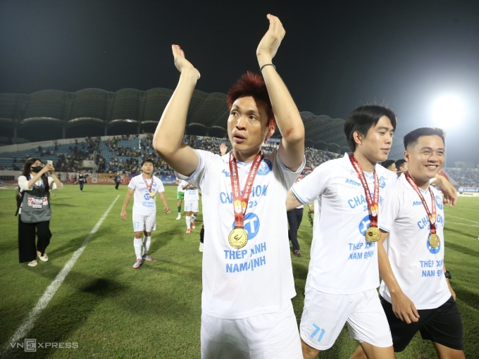 Tiền vệ Nam Định Nguyễn Tuấn Anh (trái) cảm ơn khán giả sau khi vô địch V-League 2024-2025, sau trận thắng Hà Tĩnh 1-0 ở vòng 26, trên sân Thiên Trường, Nam Định ngày 22/6/2025. Ảnh: Hiếu Lương