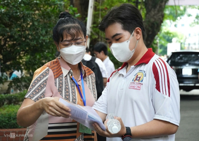 Giám thị hướng dẫn vị trí phòng thi, sáng 1/6. Ảnh: Lệ Nguyễn