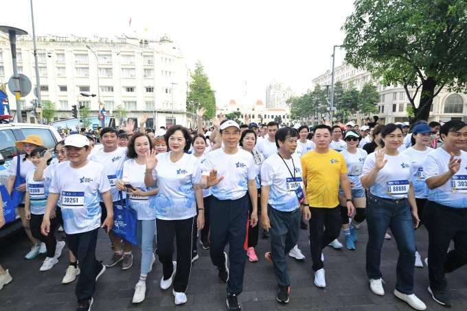 Bí thư Nguyễn Văn Nên ( đội nón, giữa) cùng Thống đốc Ngân hàng Nhà nước Nguyễn Thị Hồng đi bộ trên đường Nguyễn Huệ sáng 15/6. Ảnh: BTC