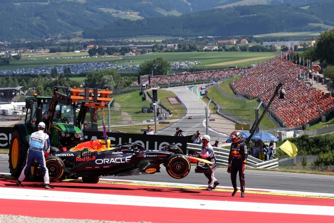 Verstappen (phải) nhìn chiếc RB21 được cẩu khỏi đường đua sau va chạm với Antonelli. Ảnh: Reuters