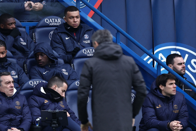 Kylian Mbappe ngồi trên ghế dự bị nhìn về phía HLV Luis Enrique trong trận PSG hòa Reims 2-2 ở vòng 21 Ligue 1 trên sân Parc des Princes, Paris ngày 10/3. Ảnh: AFP