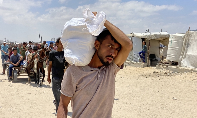 Người đàn ông Palestine vác bao lương thực từ trung tâm phân phối hàng viện trợ ở Khan Younis, phía nam dải Gaza, ngày 28/5. Ảnh: AFP