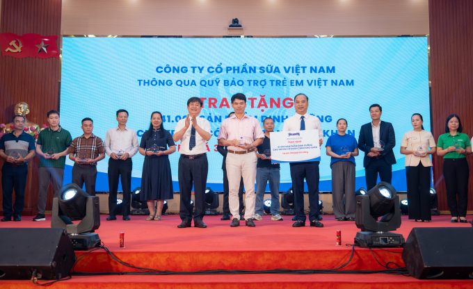 Ông Phạm Tuyên, Giám đốc chi nhánh Vinamilk Hà Nội (đứng giữa) trao bảng tượng trưng món quà 41.000 hộp sữa cho trẻ em Phú Thọ. Ảnh: Minh Hà
