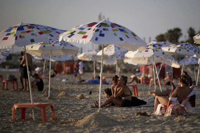 Người Israel tắm nắng ở bãi biển Tel Aviv ngày 13/6. Ảnh: AP