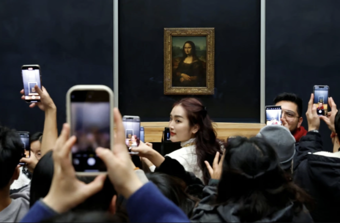 Du khách chụp ảnh bức họa Mona Lisa tại bảo tàng Louvre ở Paris vào ngày 23/1. Ảnh: Reuters