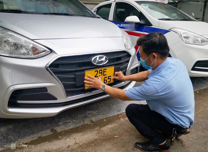 Tài xế xe taxi ở Hà Nội gắn biển màu vàng lên xe. Ảnh: Phương Sơn