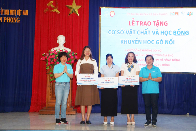 Chủ tịch (phải) và Giám đốc điều hành (phải) Quỹ Hy vọng đại diện đơn vị tài trợ trao bảng tượng trưng thư viện điện tử cho 3 trường ở Gò Nổi, trị giá 225 triệu đồng. Ảnh: Ngọc Huy