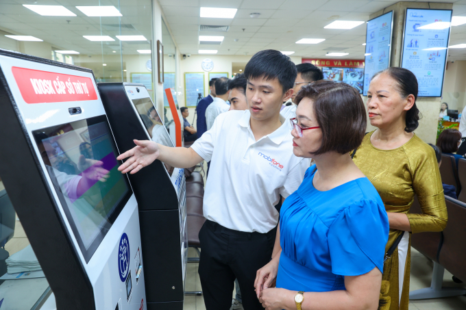 Cán bộ kỹ thuật MobiFone hướng dẫn người dân thao tác trên hệ thống thông tin giải quyết thủ tục hành chính theo mô hình mới. Ảnh: MobiFone