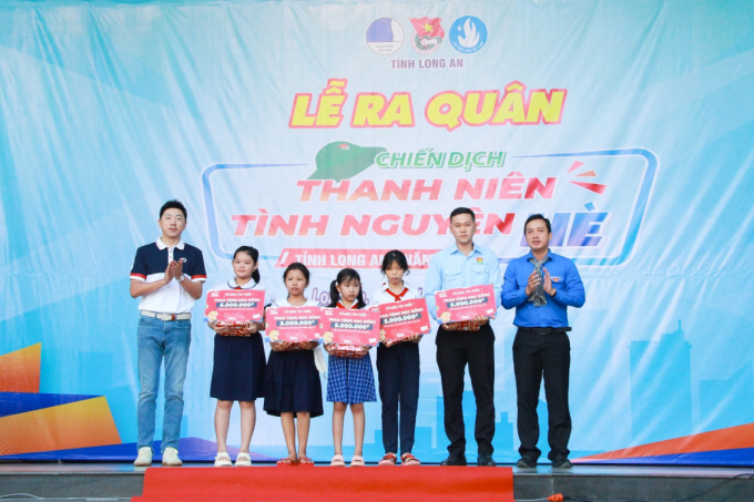 Ông Gavin Lu - Tổng giám đốc BEST Express (bên trái) cùng ông Trần Hải Phú - Bí thư Tỉnh đoàn Long An (bên phải) trao quà khuyến học cho các em học sinh. Ảnh: BEST Express