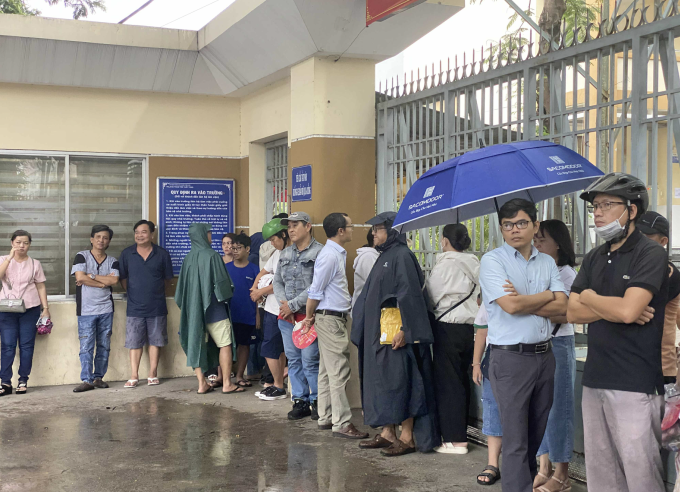 Phụ huynh đợi con trước cổng trường ở quận 5, TP HCM, trưa 26/6. Ảnh: Ngọc Ngân