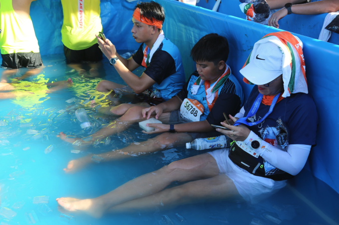 Runner ngâm chân nước đá sau khi hoàn thành giải VnExpress Marathon Quy Nhơn 2022. Ảnh: VnExpress Marathon