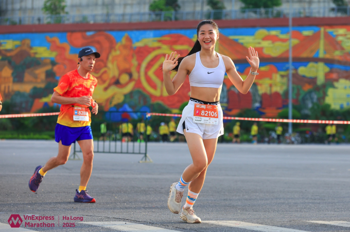 Runner Cao Yến Ngọc vẫy chào các nhiếp ảnh gia khi tham gia cự ly 21km tại VnExpress Marathon Hạ Long. Ảnh: VnExpress Marathon