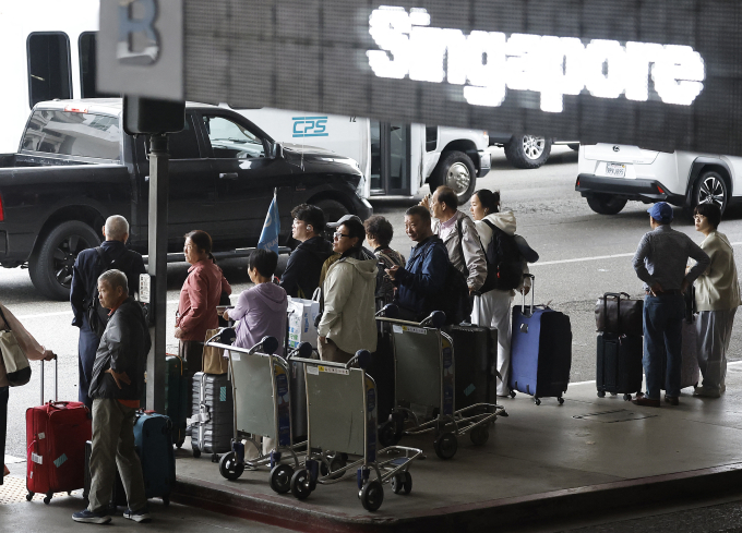 Hành khách tập trung bên ngoài sân bay quốc tế ở thành phố Los Angeles, bang California, Mỹ ngày 6/6. Ảnh: AFP