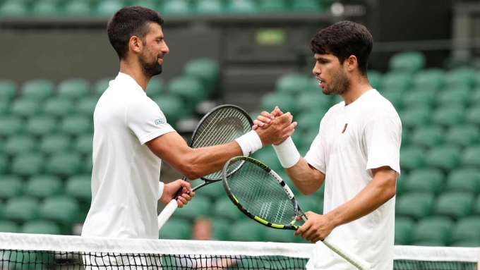 Djokovic đánh tập với Alcaraz (phải) trên sân Trung tâm tại All England Club, London, Anh hôm 27/6. Ảnh: Reuters
