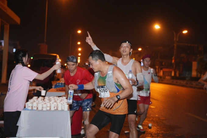 Runner nạp điện giải trên đường chạy VnExpress Marathon. Ảnh: VnExpress Marathon