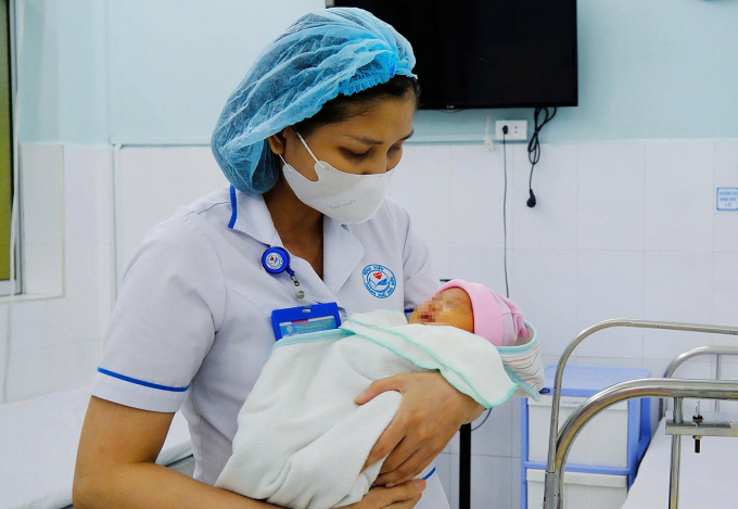 Bé gái trong vòng tay nhân viên y tế. Ảnh: Bệnh viện cung cấp