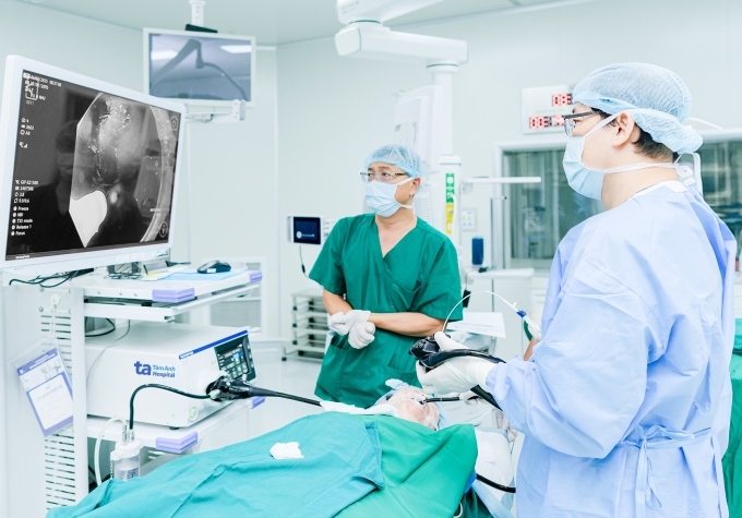 Bác sĩ Hùng bóc tách khối u dưới niêm bằng ống mềm cho chị Tiên. Ảnh: Bệnh viện Đa khoa Tâm Anh