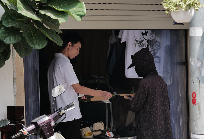 Một cửa hàng trên phố Hàng Ngang (quận Hoàn Kiếm) mở khi có khách hoặc shipper đến giao nhận, ngày 8/6. Ảnh: Ngọc Thành