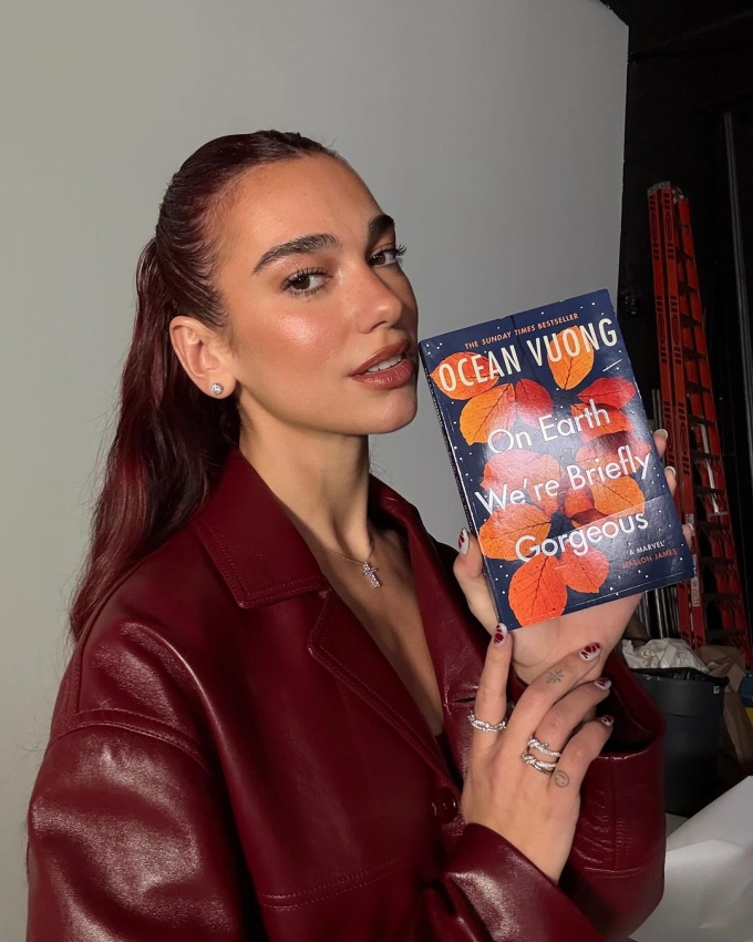 Dua Lipa và cuốn sách Một thoáng ta rực rỡ ở nhân gian (Ocean Vuong). Ảnh: Service95