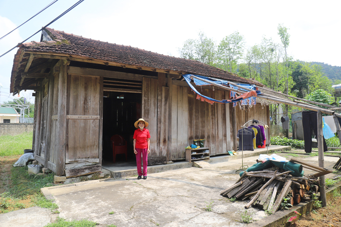 Bà Hương bên ngôi nhà cấp bốn lụp xụp, luôn dọa sập. Ảnh: Đức Hùng