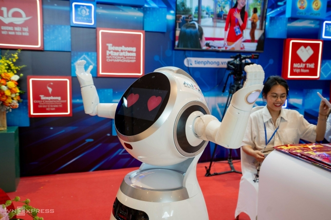 Gian trưng bày của báo Tiền Phong nổi bật với hình ảnh robot giúp độc giả trải nghiệm đọc báo trên màn hình lớn bằng cách ra lệnh bằng giọng nói. Ảnh: Hoàng Giang