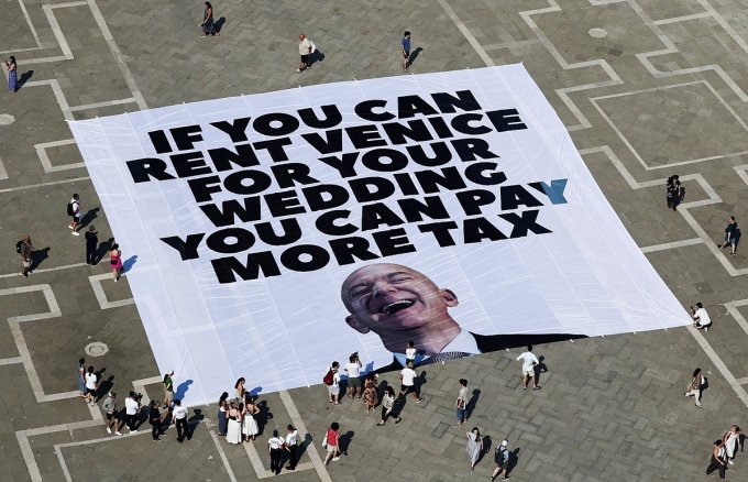 Greenpeace Italy và Everyone Hates Elon (Ai cũng ghét Elon Musk) giăng biểu ngữ kêu gọi ông Bezos đóng thêm thuế. Ảnh: Reuters