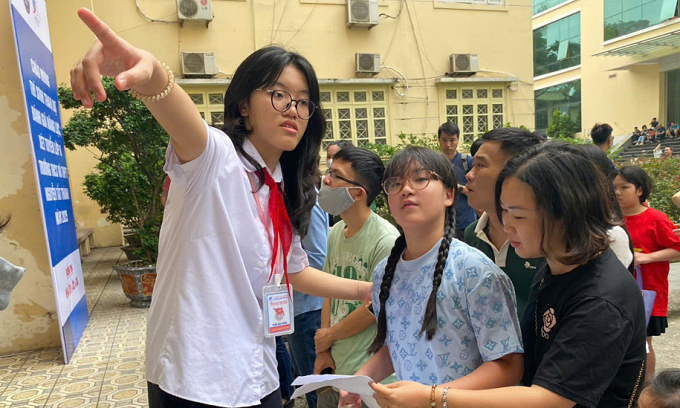 Tình nguyện viên hướng dẫn thí sinh thi vào lớp 6 trường THCS và THPT Nguyễn Tất Thành, Hà Nội, sáng 31/5. Ảnh: Bình Minh