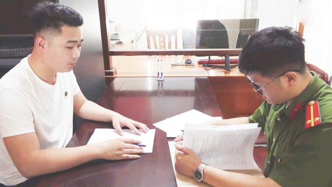 Trần Tuấn Anh (góc trái) làm việc với cảnh sát. Ảnh: Công an cung cấp