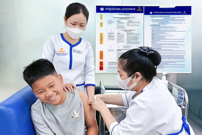 Phụ huynh đưa trẻ đi tiêm ngừa sốt xuất huyết tại Trung tâm tiêm chủng VNVC. Ảnh: Hoàng Dương