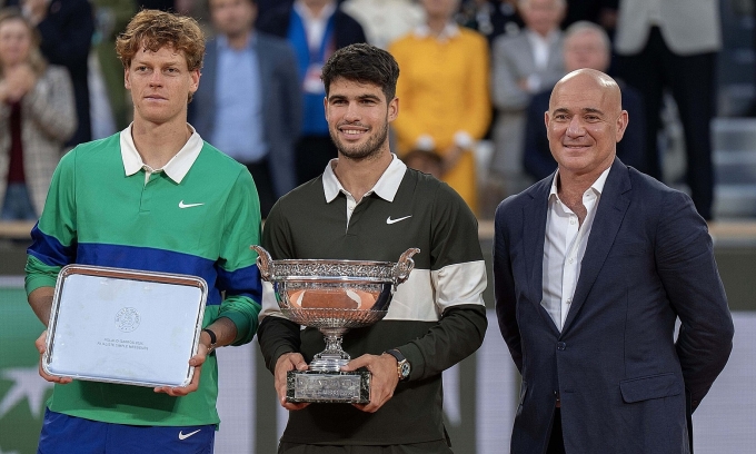 Alcaraz (giữa) và Sinner (trái) cùng huyền thoại Andre Agassi trên bục nhận giải, sau chung kết Roland Garros, tại sân Philippe Chatrier, Paris, Pháp hôm 8/6. Ảnh: Reuters