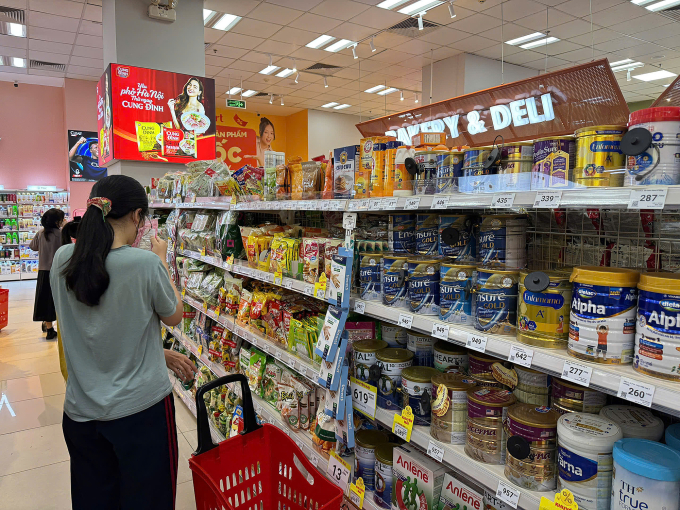 Một khách hàng cẩn thận kiểm tra thông tin trên bao bì sản phẩm trước khi mua tại một siêu thị ở quận Thanh Xuân, Hà Nội, tối 9/6. Ảnh: Nga Thanh