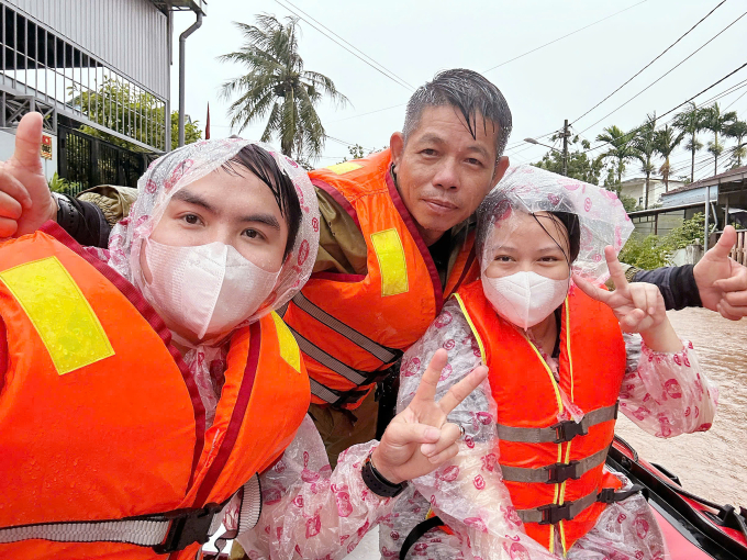 Anh Nguyễn Mậu Anh Tuấn và vợ chồng sản phụ chụp ảnh kỷ niệm trước khi xuống cano để di chuyển vào bệnh viện Triệu Hải, sáng 13/6. Ảnh: Mậu Tuấn