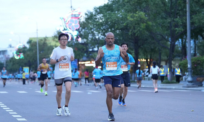 Tissa Dissanayake giơ ngón tay cái chào ống kính trên đường chạy 21km tại Quy Nhơn. Ảnh: VnExpress Marathon