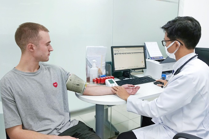 Bác sĩ Đạt khám sàng lọc và tư vấn cho chàng trai người Anh. Ảnh: Hoàng Dương