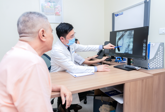 Ông Nhàn được bác sĩ giải thích tình trạng viêm tụy trong ngày tái khám. Ảnh: Bệnh viện Đa khoa Tâm Anh