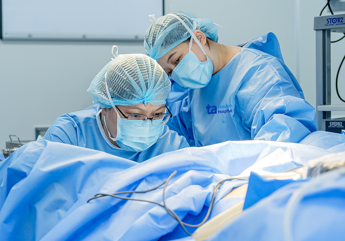 Bác sĩ Thoại (trái) phẫu thuật cho chị Hằng. Ảnh: Thanh Luận