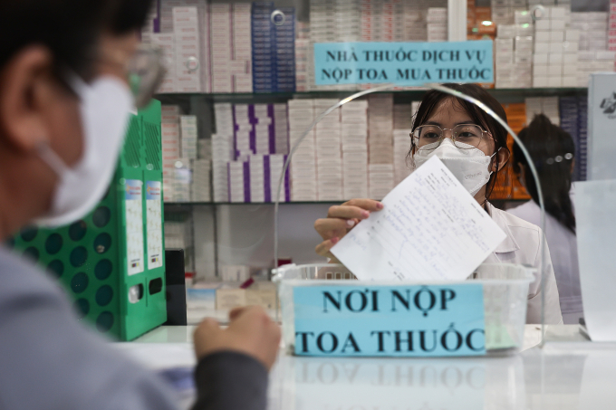Nhân viên y tế tại nhà thuốc Bệnh viện Quân y 175 phát thuốc cho bệnh nhân. Ảnh: Quỳnh Trần